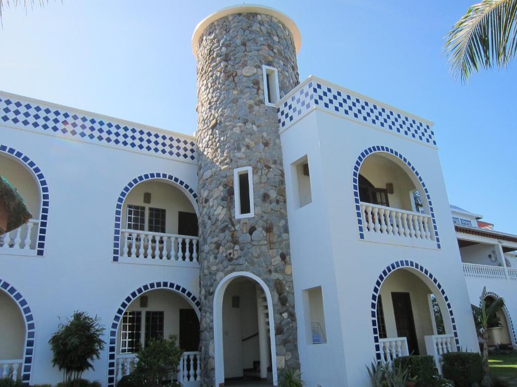 a white building with arches and a tower at Squares Beachside Apartments in Puerto Galera