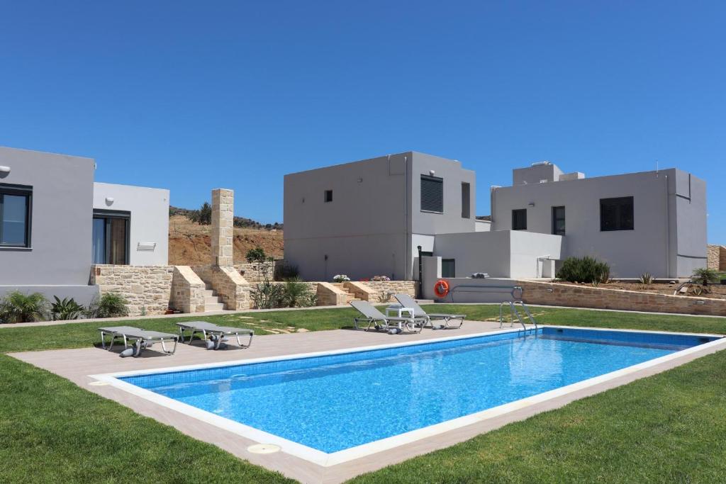 a villa with a swimming pool in front of a house at Triopetra View 2 in Triopetra