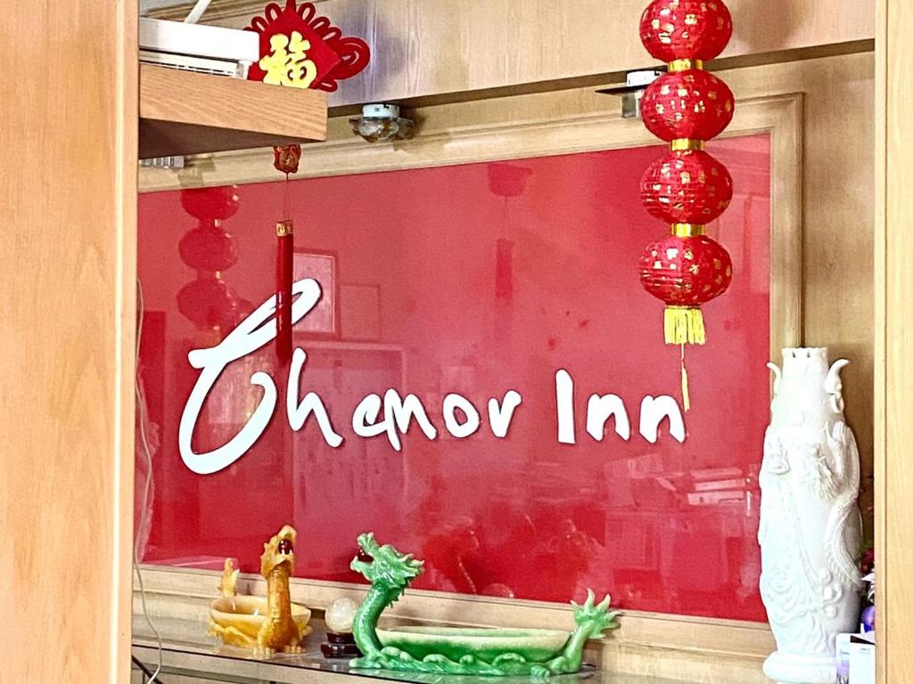 una ventana con un letrero chino en una tienda en Chemor Inn, en Cemur
