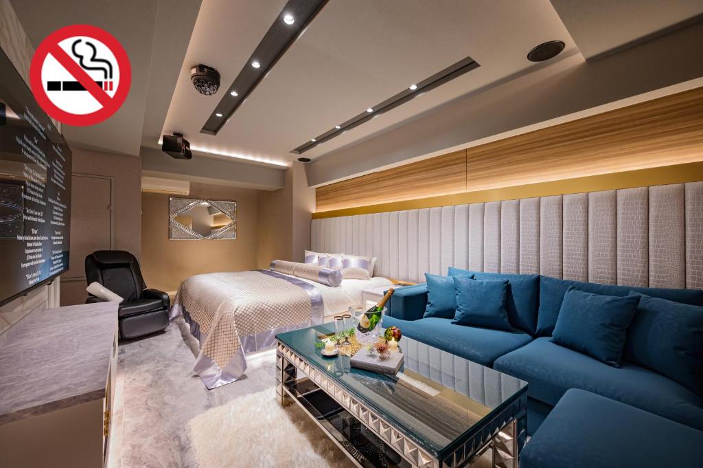 a hotel room with a bed and a blue couch at HOTEL VARKIN Ikebukuro Nishiguchi in Tokyo
