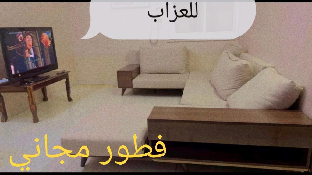 a living room with a couch and a tv at Hostel 35 in Al Madinah