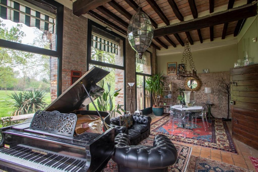 a living room with a piano and a table at La Corte vicino Maranello in Montale
