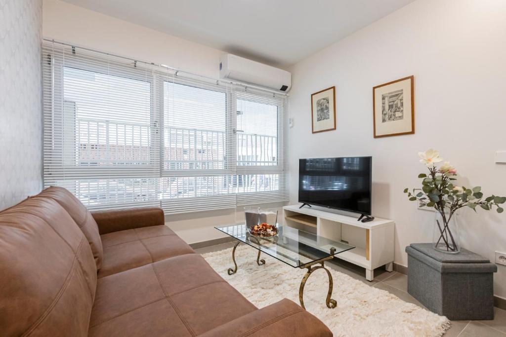 sala de estar con sofá y TV de pantalla plana en Dobohomes - Clara del Rey 33, en Madrid