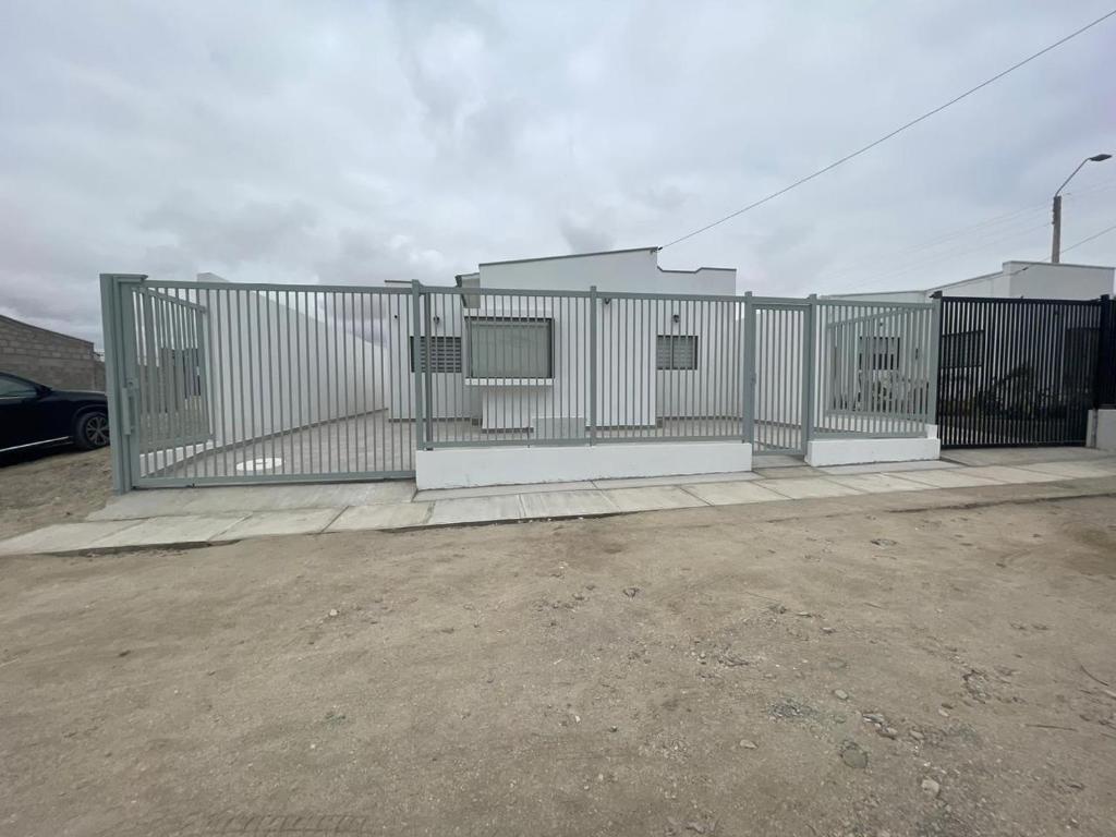 una cerca de metal en un estacionamiento con un coche en Casa condominio costa del Sol a 1.4 km de Bahía Inglesa, en Caldera