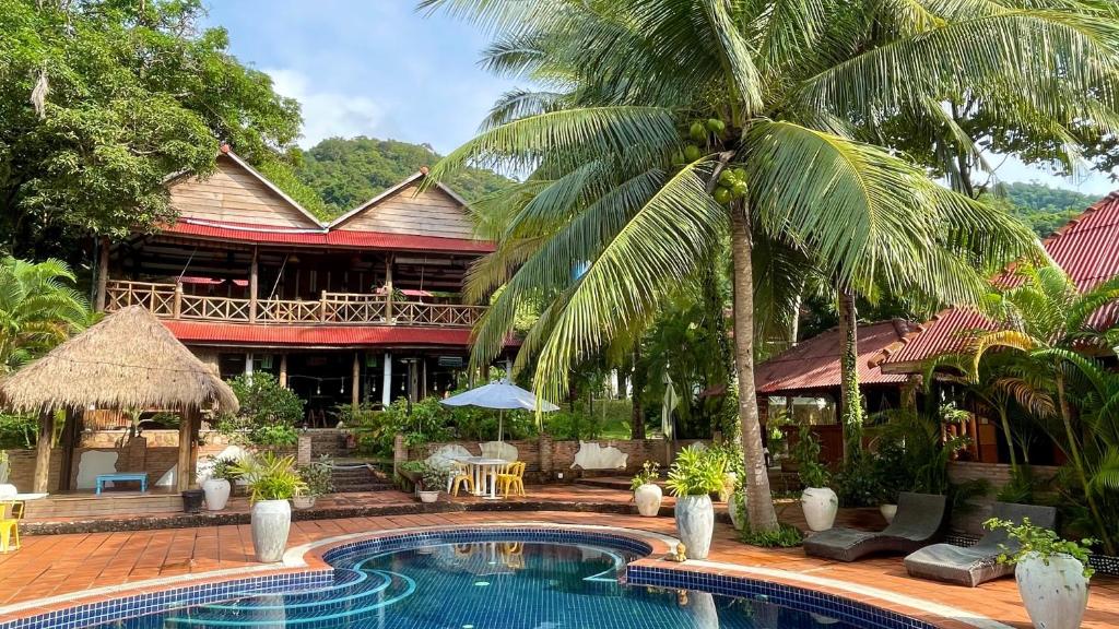 a resort with a swimming pool in front of a building at Kep Lodge in Kep