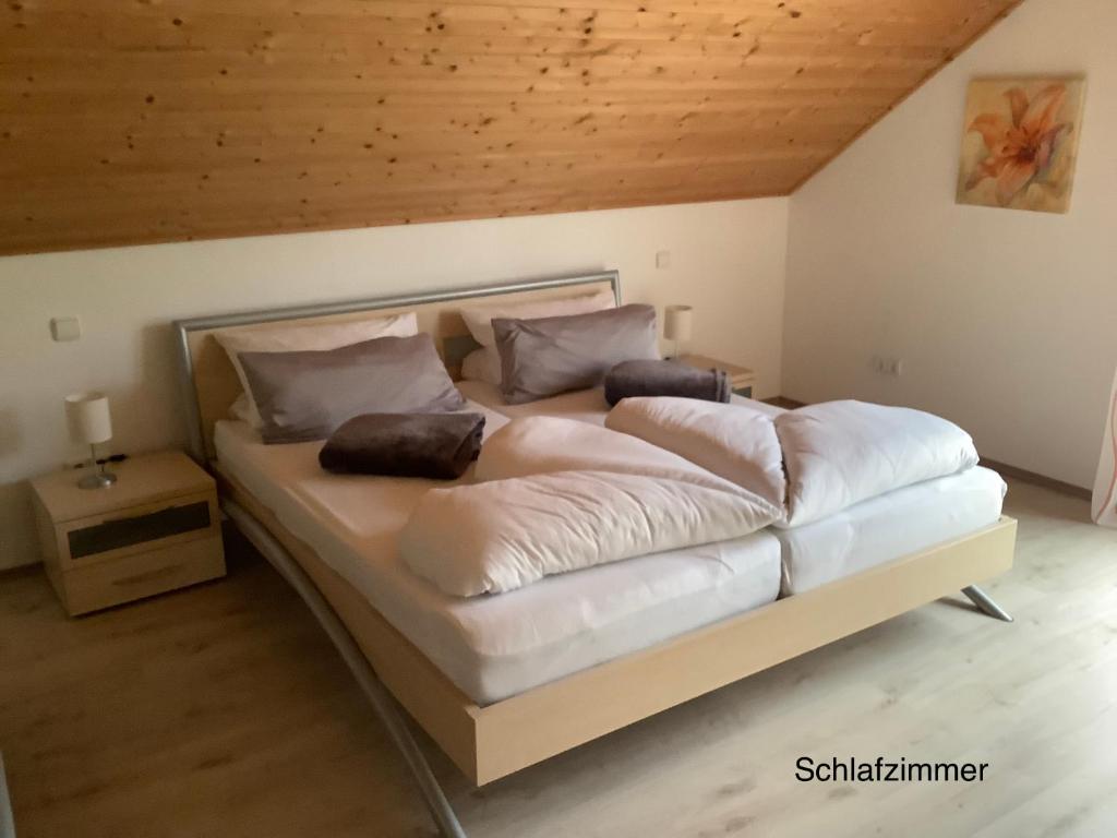 Cama grande en habitación con techo de madera en Wohlfühloase am Michelsberg, en Bad Münstereifel