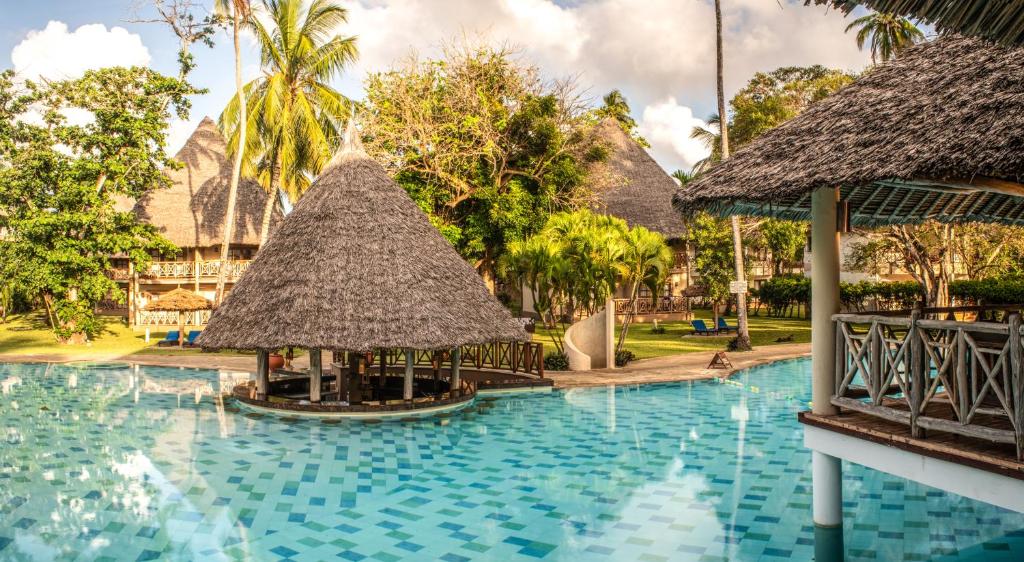 een zwembad in een resort met een resort bij Neptune Palm Beach Boutique Resort & Spa - All Inclusive in Galu