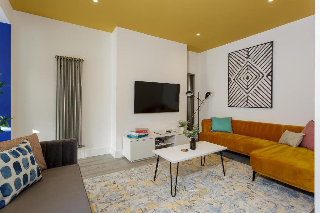 sala de estar con sofá y TV en Heyshott Manor - Luxury 5 bedroom house in Portsmouth en Portsmouth