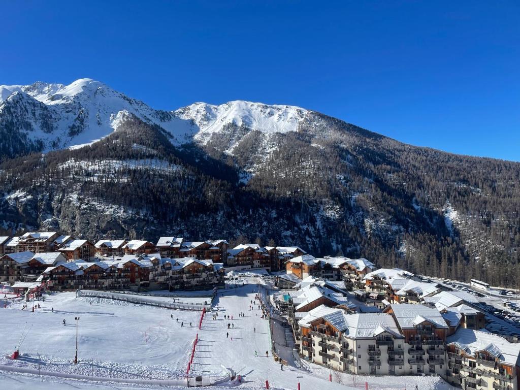una estación de esquí en la nieve con una montaña en Appt 4 a 6 pers aux pieds des pistes Les terrasses du soleil d or résidence avec piscine en Les Orres
