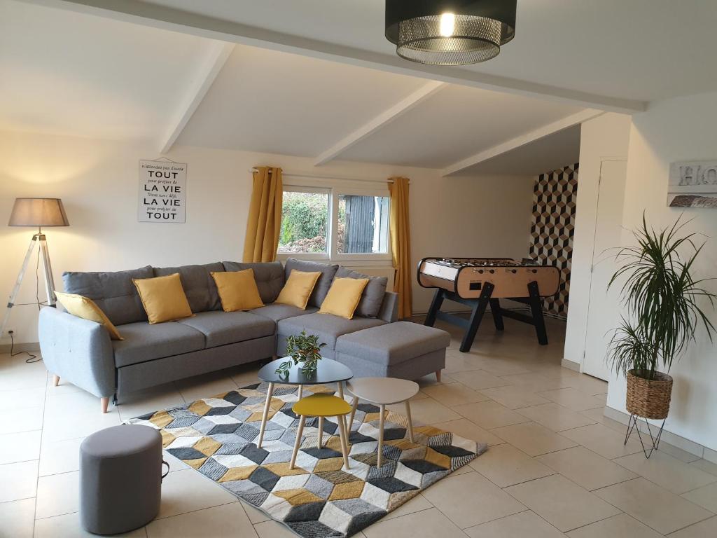 uma sala de estar com um sofá e uma mesa em Gîte la crinière au vent em Étréaupont