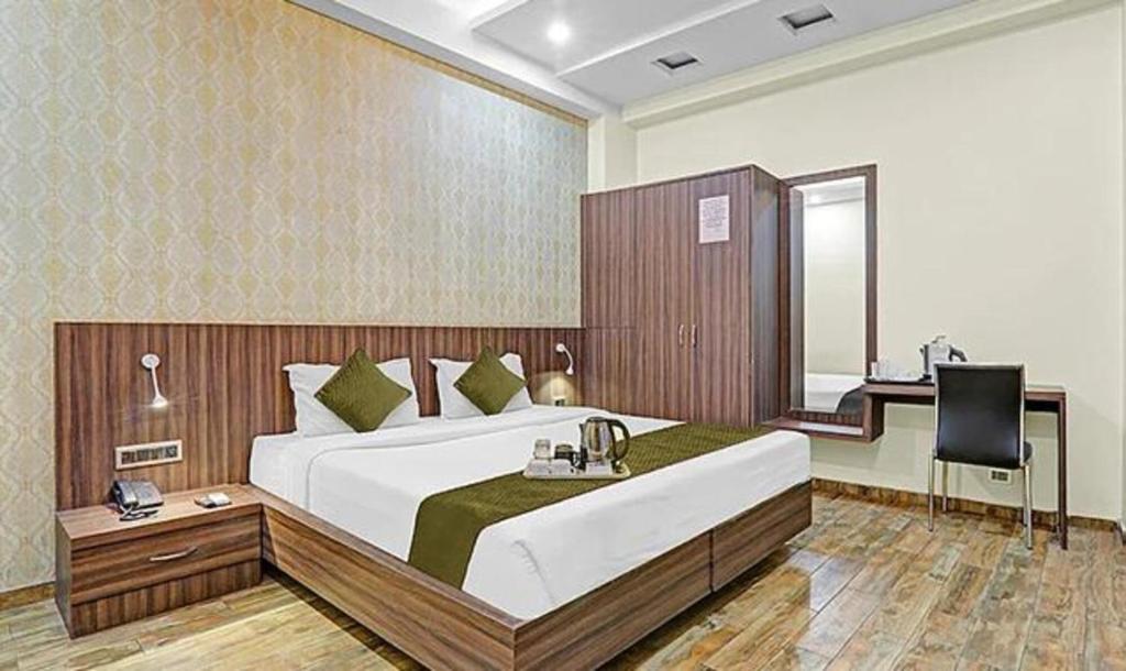1 dormitorio con 1 cama grande y escritorio en FabHotel Sam Inn en Lucknow