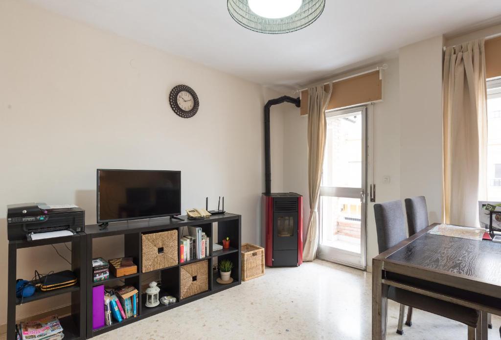 a living room with a table and a television at Rafaela Guest House in Málaga