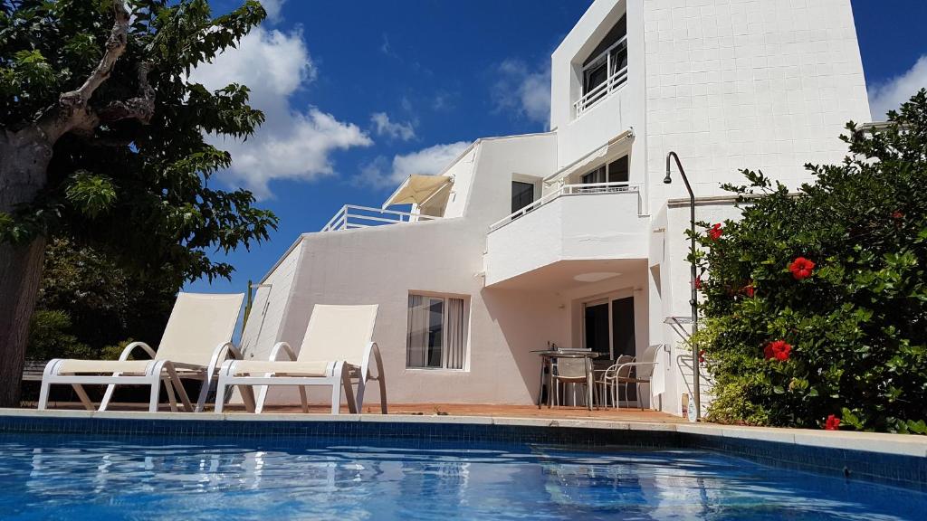 Villa con piscina frente a una casa en STARBAL Love en Es Castell