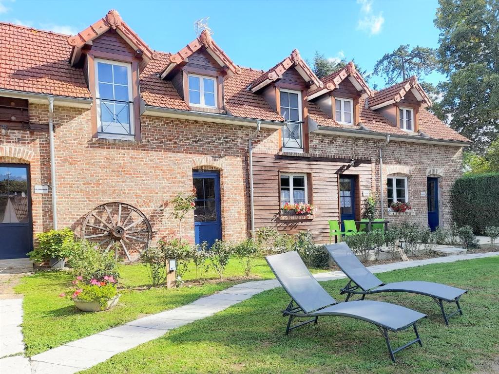 two chairs in front of a brick house at Gîtes "Aux Charmes de la Baie" labellisés 3 clévacances avec parking et terrain clos in Buigny-Saint-Maclou