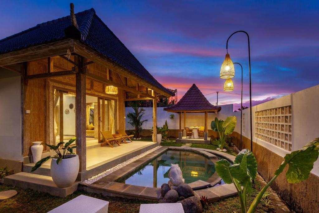 a villa with a swimming pool and a house at Amaya Sebatu Villa in Ubud