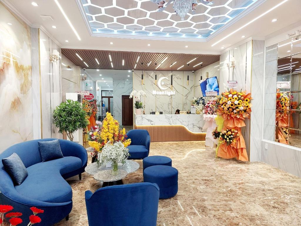un vestíbulo con sillas azules y una mesa en una tienda en Moonlight Nha Trang Hotel, en Nha Trang