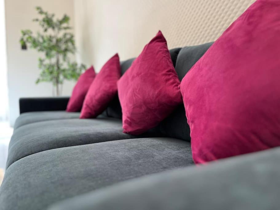 a row of pink pillows on a gray couch at Beautiful 4-Bedroom Townhouse in Sliema in Sliema