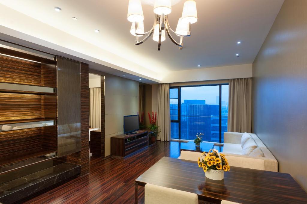 uma sala de estar com um lustre e uma mesa em Yicheng Pazhou Poly World Trade Centre Apartment em Guangzhou