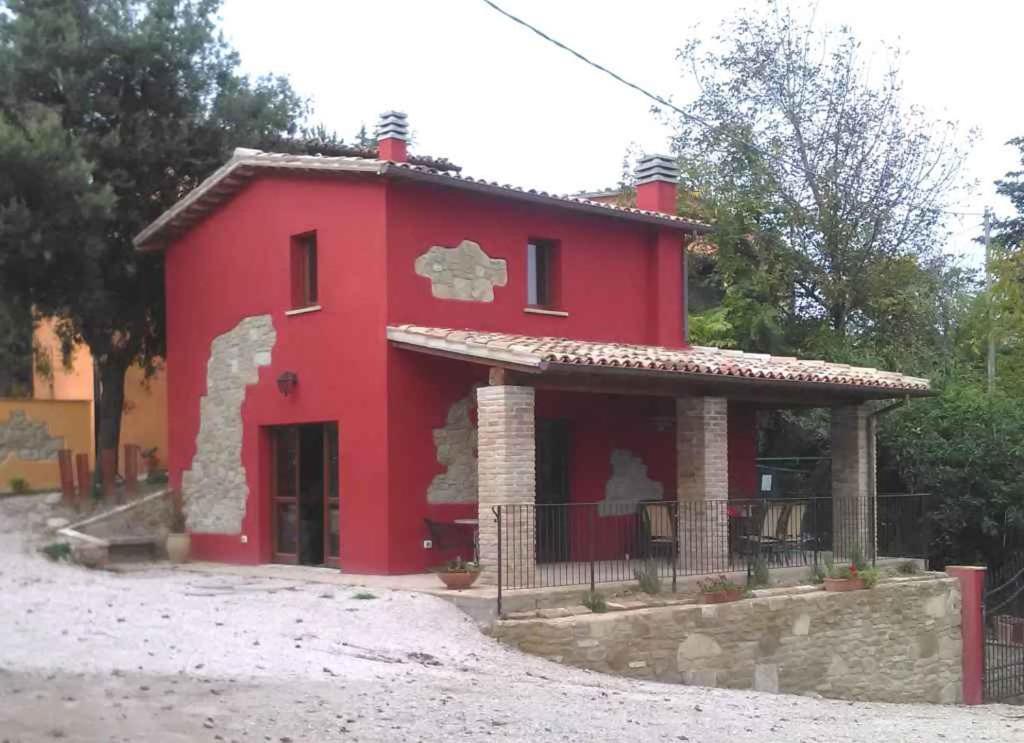 a red house with a fence in front of it at Holiday home in Urbino - Marken 35804 in Urbino