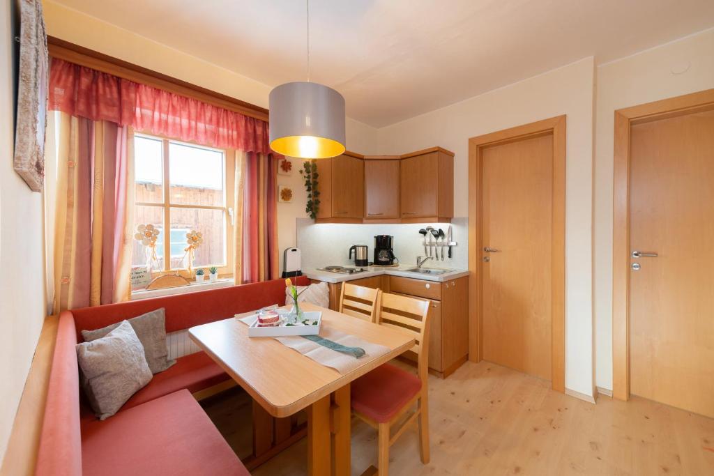 ein Wohnzimmer mit einem Tisch und einer Küche in der Unterkunft Molteraugut in Mühlbach am Hochkönig