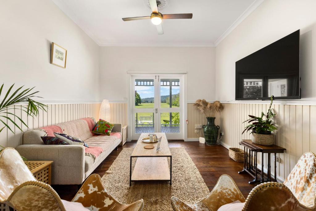 una sala de estar con un sofá y una mesa en 4 Bedroom Farm Cottage on the Bellinger River, en Bellingen