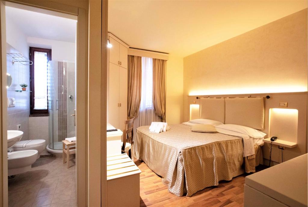Postel nebo postele na pokoji v ubytování Hotel Arcobaleno Siena