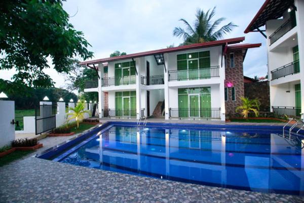 a house with a swimming pool in front of a house at Hotel Sanri Villa Katunayake in Minuwangoda