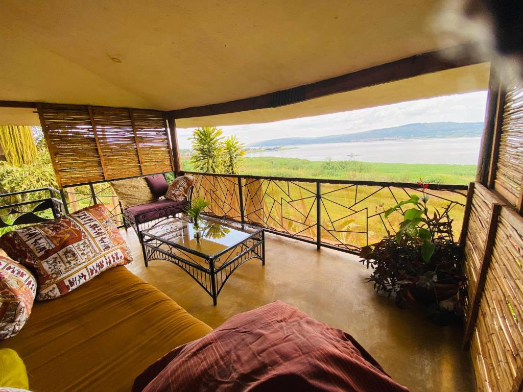 uma sala de estar com um sofá e uma mesa na varanda em Home On The Nile Ernest Hemingway Suite em Jinja