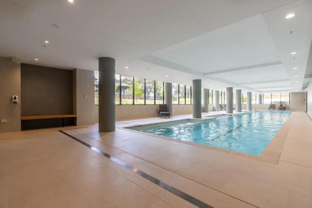 a large swimming pool in a building at New & Modern Loft 1bd w/Pool&Gym in Canberra