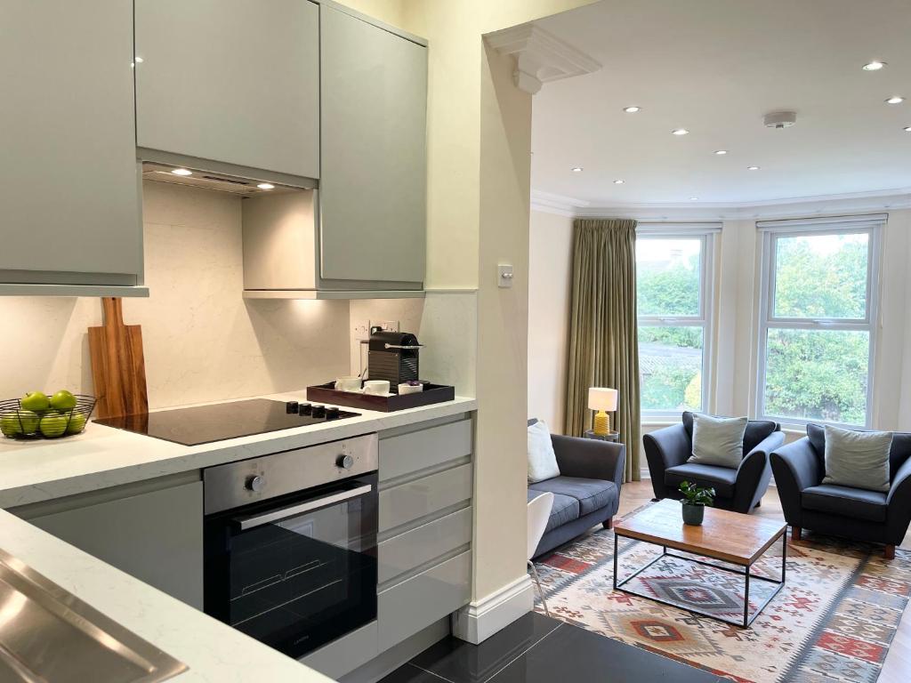 a kitchen and a living room with a couch at Glenlyn Apartments in Whetstone