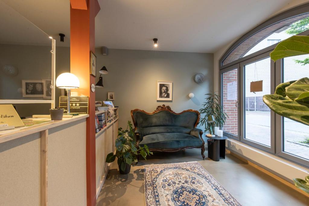 a living room with a couch and a window at Altstadthotel Eibsen in Otterndorf