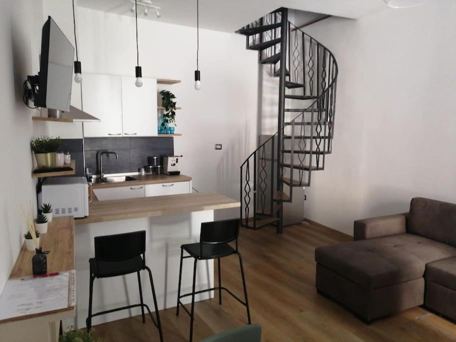 a kitchen and a living room with a spiral staircase at Casetta San Giorgio in Vallata