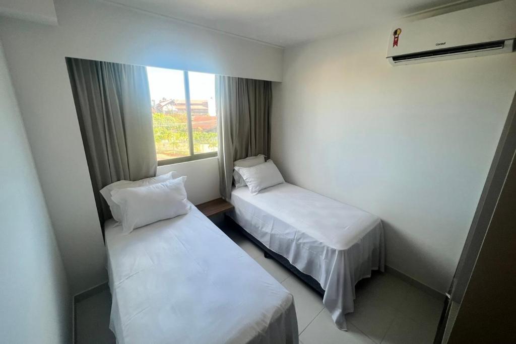 2 camas en una habitación pequeña con ventana en Mana beach 2 quartos Muro Alto Ipojuca, en Ipojuca