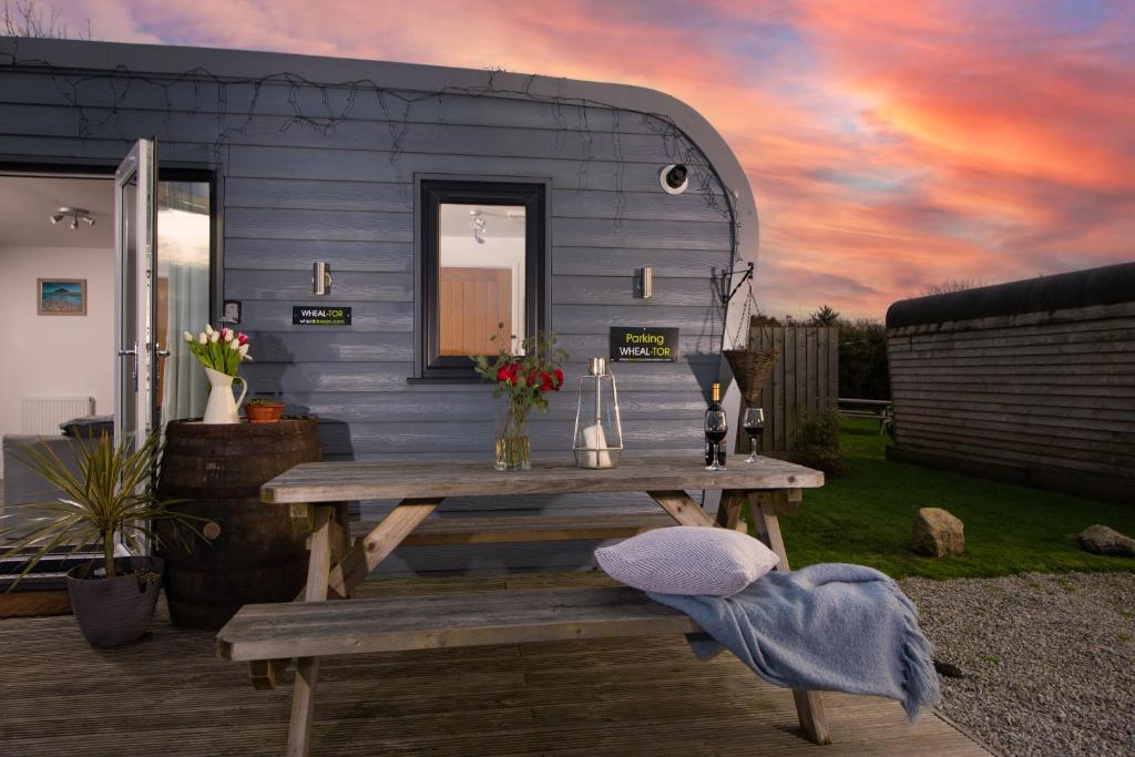 a picnic table in front of a tiny caravan at Wheal Tor- Beautifully Fitted Wooden Lodge Helston Cornwall in Helston