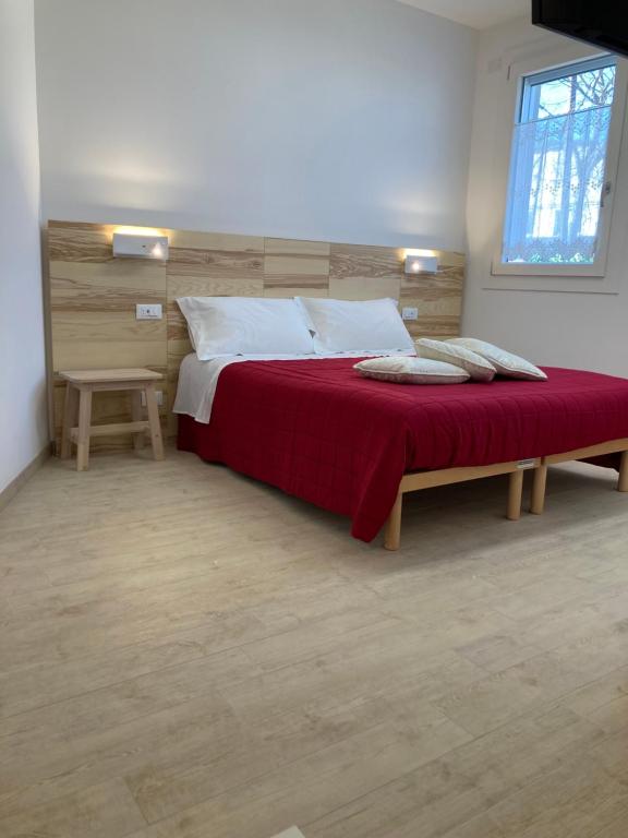 - une chambre avec un grand lit et une couverture rouge dans l'établissement ALLA CASA DEI NONNI, à Campodarsego