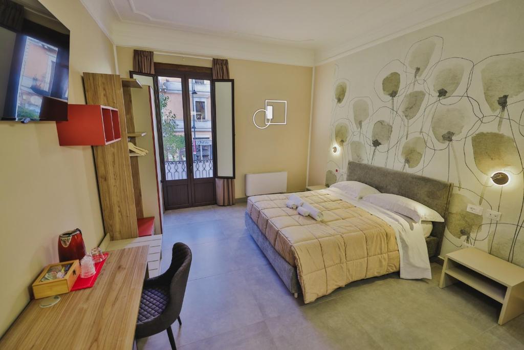 a bedroom with a bed and a desk and a tv at Brettia Guest Rooms in Cosenza