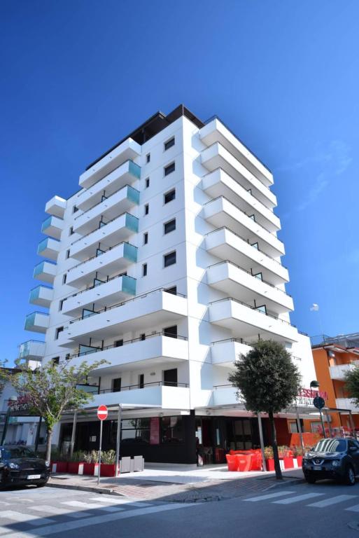 リニャーノ・サッビアドーロにあるAparthotel Alessandriaの駐車場付き白いアパートメントビル