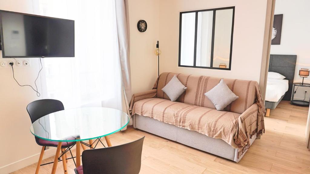een woonkamer met een bank en een glazen tafel bij Centre Cannes, Appartement 301, 1 room By Palmazur in Cannes