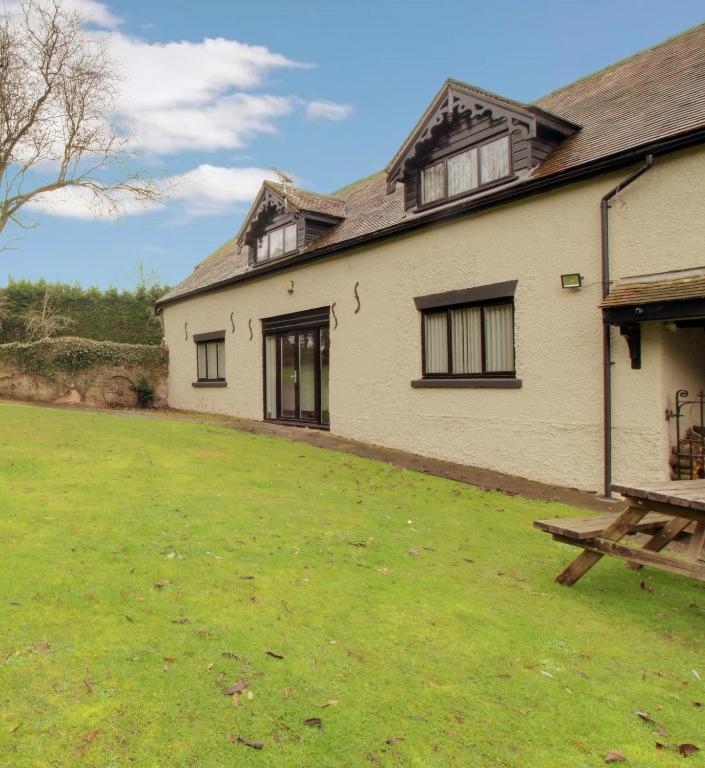 a house with a grass yard in front of it at Stable Cottage in Ross on Wye