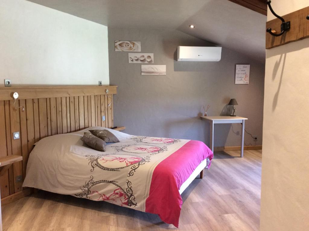 Un dormitorio con una cama y una mesa. en Le Mas des Figuiers, en Donzère