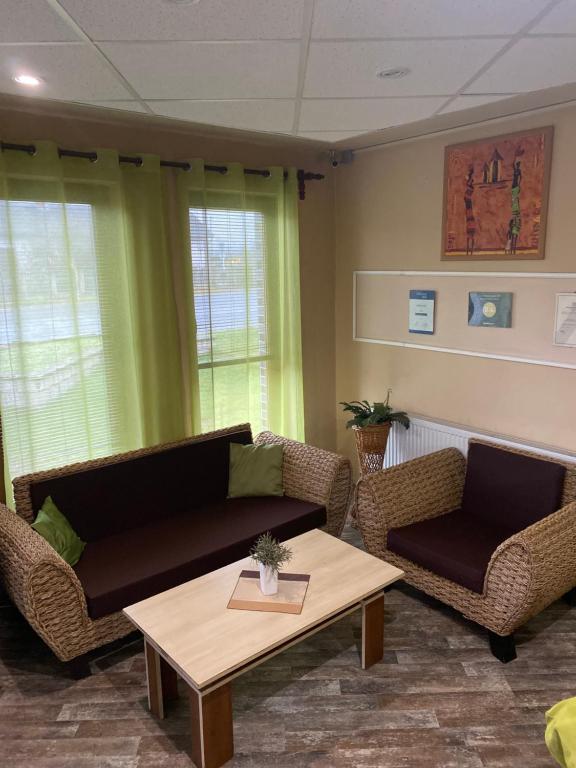 a living room with a couch and chairs and a table at Abszolút Hotel és Panzió in Nyírbátor