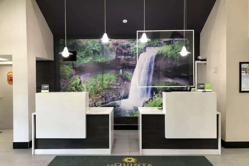 a large painting of a waterfall on the wall in a room at La Quinta by Wyndham Minneapolis Northwest in Brooklyn Park