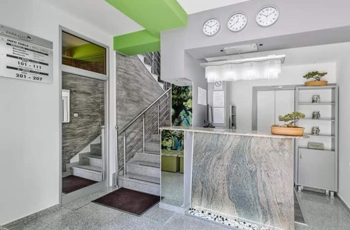 a lobby with a staircase and clocks on the wall at Bed & Breakfast Park Gate in Vranje