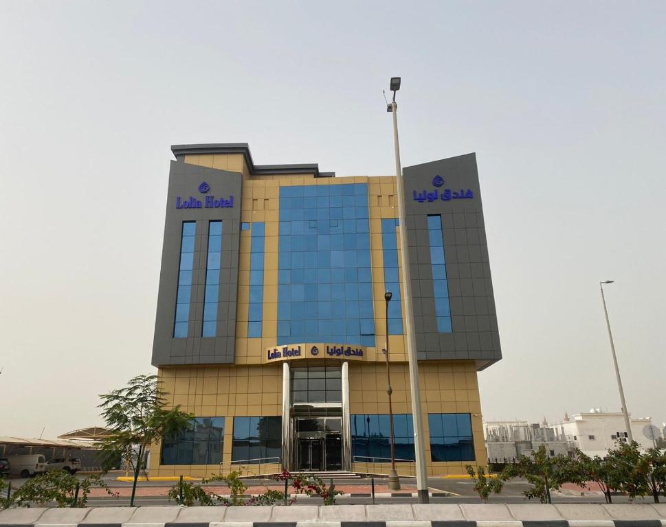 a building with a sign on the side of it at Lolia Hotel فندق لوليا الفندقية in Raʼs Tannūrah