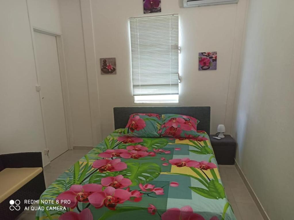 a bedroom with a bed with pink flowers on it at L'étonnant F3 Joris in Saint-Pierre