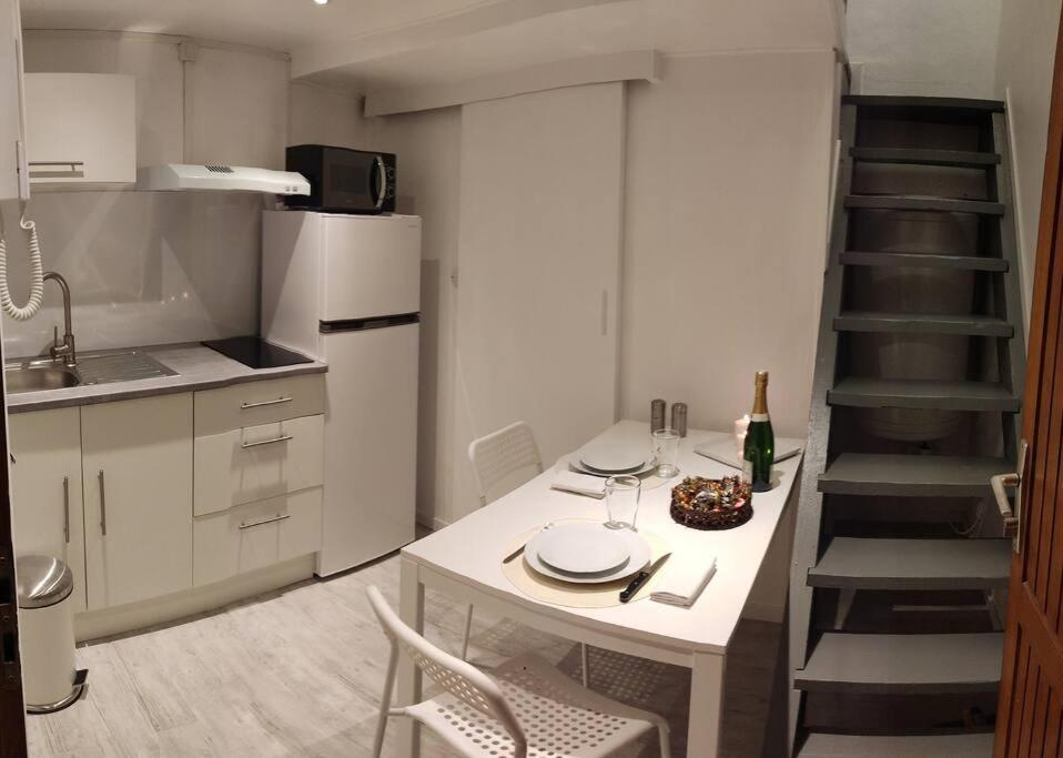 une petite cuisine avec une table et un escalier dans l'établissement Studette Rémoise, à Reims