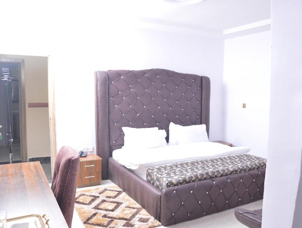 a bedroom with a bed with a large headboard at Akure Airport Hotel in Oba Ile