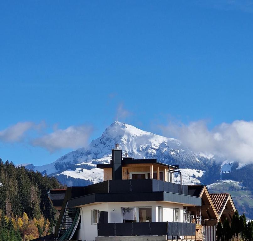 ein Haus mit einem Berg im Hintergrund in der Unterkunft Appartement Lurger in Kirchberg in Tirol