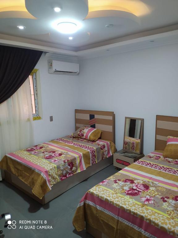1 dormitorio con 2 camas y techo en النوايف en El Cairo