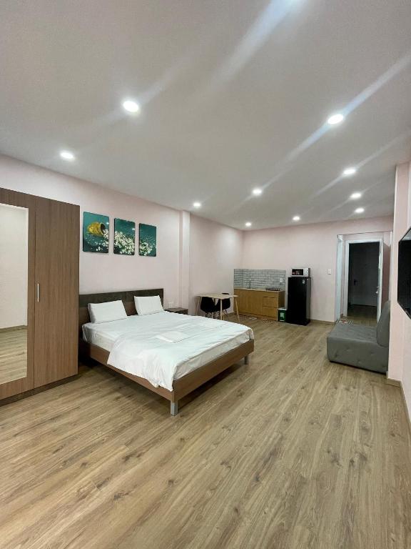 a large bedroom with a bed and a wooden floor at Aspire Saigon - Ly Tu Trong in Ho Chi Minh City